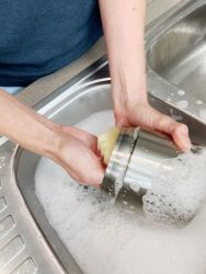 an image of the insulated food container being washed in a sink of hot soapy water